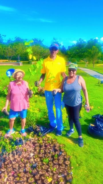 Three residents with a newly planted tree